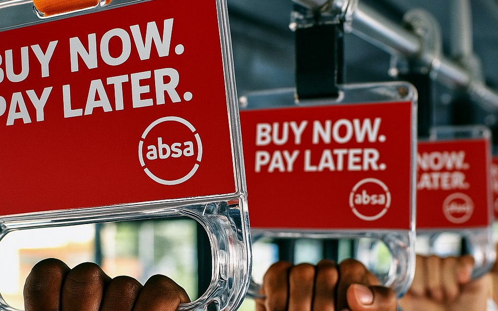 Absa Buy Now Pay Later branded grab handles held by passengers