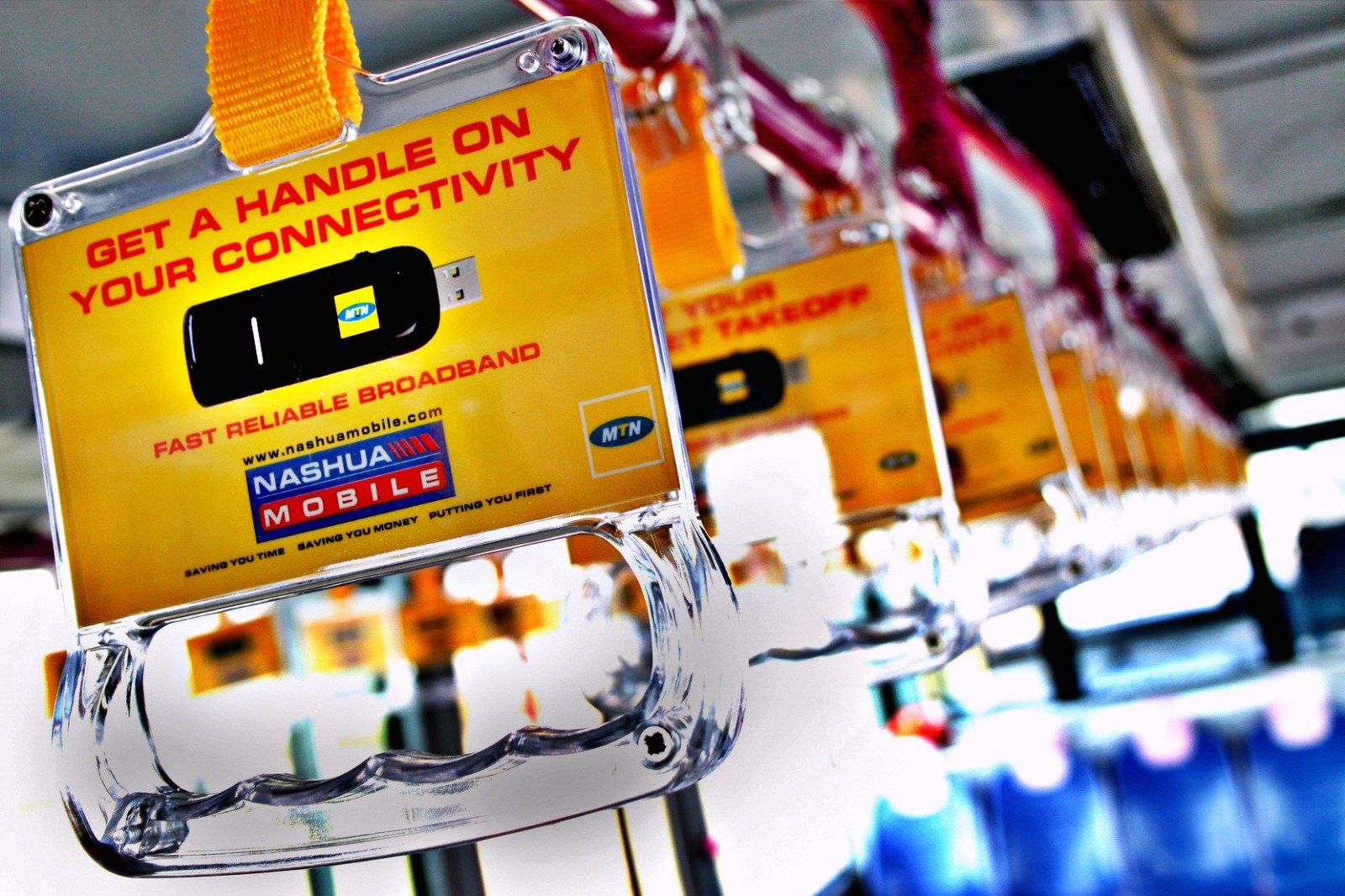 Heritage Nashua Mobile and MTN branded grab handles inside an airport bus