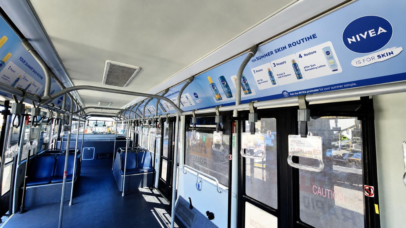 NIVEA branded interior panels running the length of an airport bus cabin