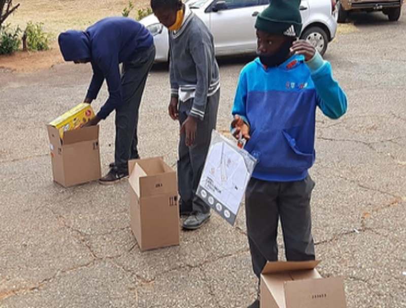 Learners unpacking boxes of new school shoes
