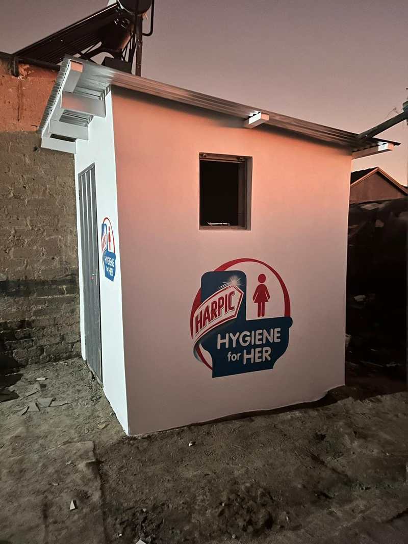 The Hygiene for Her facility standing lit at dusk