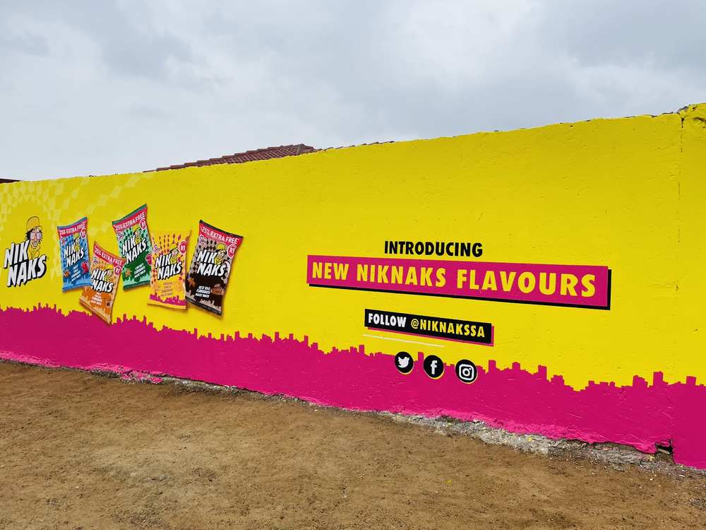 Angled NikNaks flavour wall running along a dirt road
