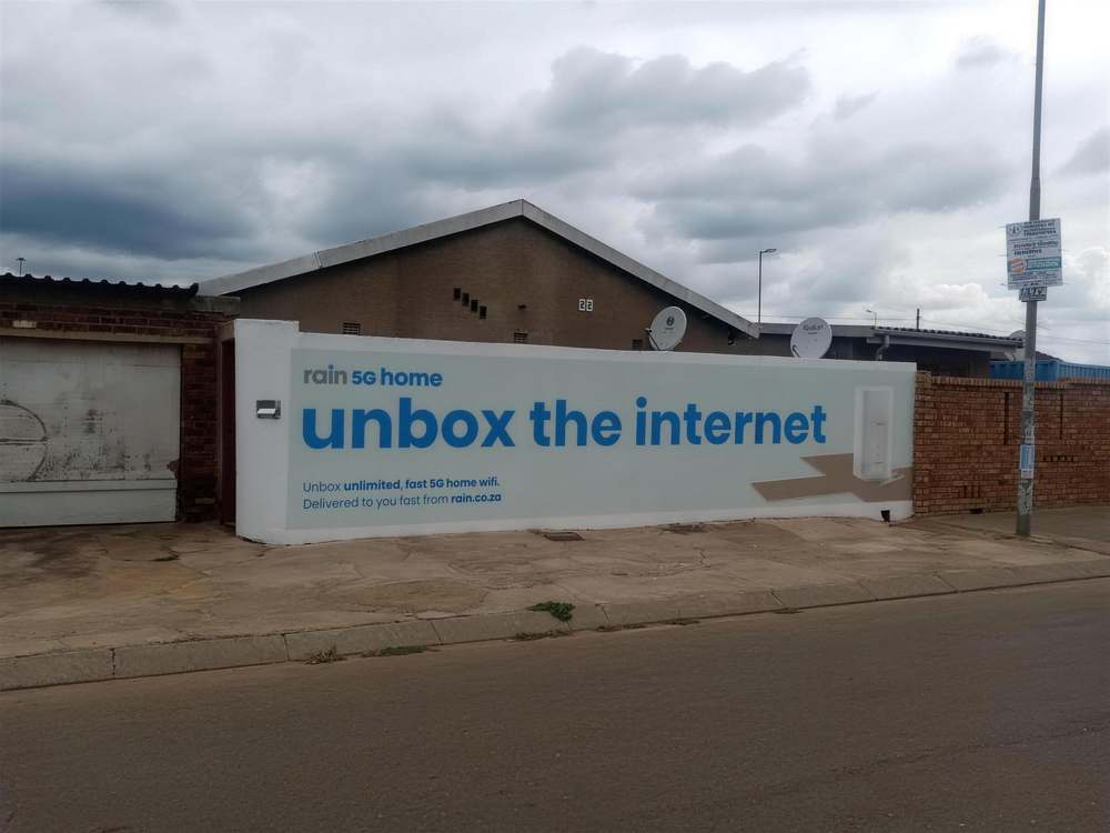 White rain 5G home wall mural reading unbox the internet on a township street