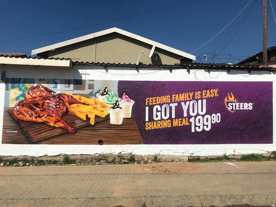 Steers sharing meal painted in 3D airbrush realism on a white wall