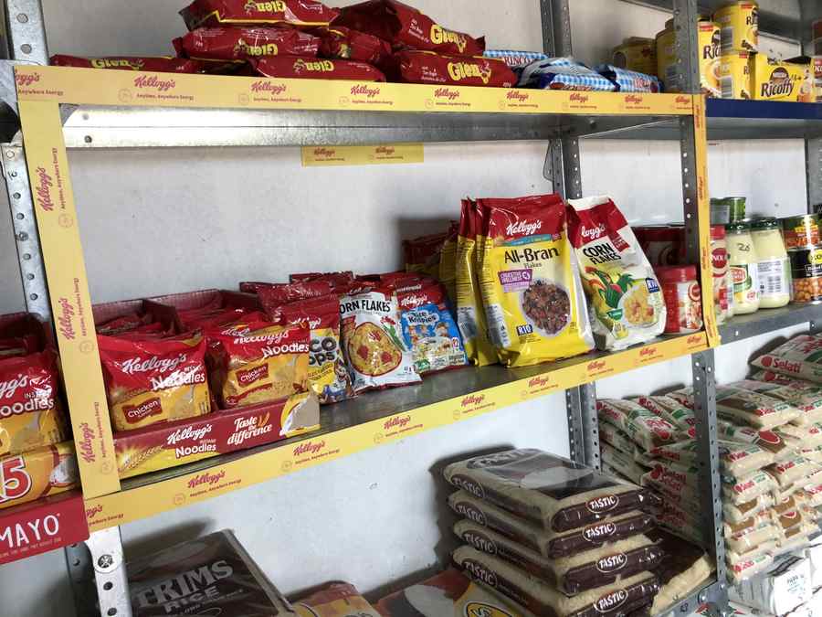 Kellogg's branded in-store shelving stacked with cereals and noodles